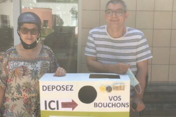 Chloé et Vincent, résidents d'Arceau devant un boite de collecte de bouchons